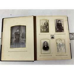 Victorian leather bound photo album, the interior leaves containing apertures of various sizes and shapes of portraits surrounded by printed floral designs, H28cm