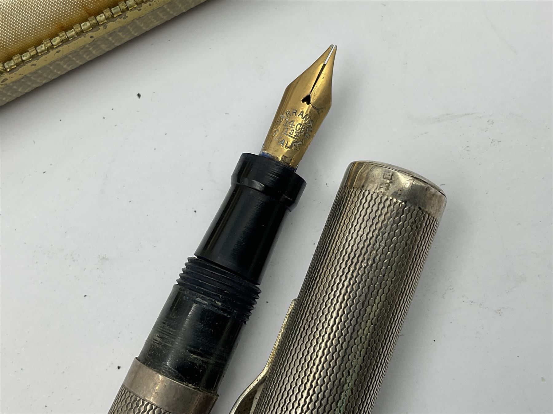 Three parker fountain pens, one example with 14ct gold plated cap and personal engraving, in Parker 51 box, together with a silver Sampson Mordan Everpoint propelling pencil with personal engraving and a silver cased fountain pen with 14ct gold nib and a souvenir bronze Dollfus-Mieg medallion, awarded to John G Sedorski, in fitted case 