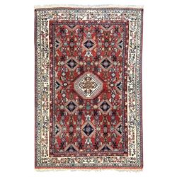 Pair of rugs one Persian hamadan rug central stepped medallion enclosing geometric motifs in ivory and brown, framed by a cream border with scrolling palmettes and fringed ends (H 156cm W 105cm), one Pakistani Bokhara rug rust red ground with repeated Tekke gul motifs within rosette and lozenged borders, fringed ends (H 98cm, W 65cm)