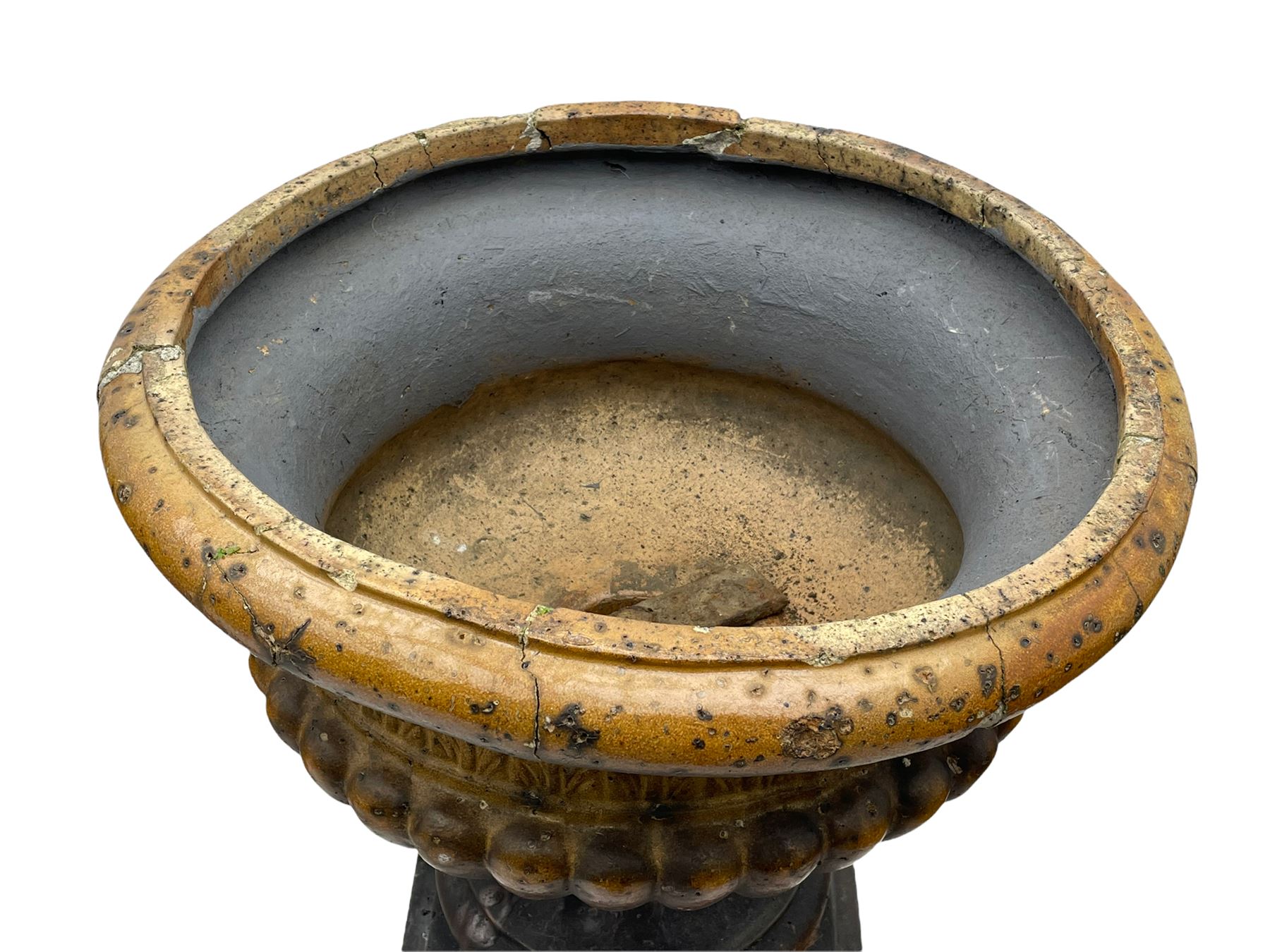 Victorian salt glazed terracotta garden urn on plinth, the Campana shaped urn with foliate decoration over gadrooned underbelly, the plinth of square tapering form, each side with recessed moulded archway decorated with urn cartouches, stepped and moulded skirt base