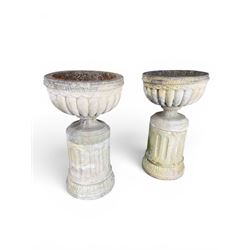 Four 20th century good quality weathered cast stone pedestal urns, circular lobed bowls with rope twist and lattice border, raised on squat base with fluted columns