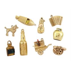 Eight 9ct gold pendant / charms including Guinness bottle, monkey organ grinder, boat, cat, poodle dog, telephone and lantern and a 14ct gold cow bell