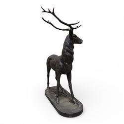 Pair of life-size cast iron garden or home stags, modelled standing upon oval plinths