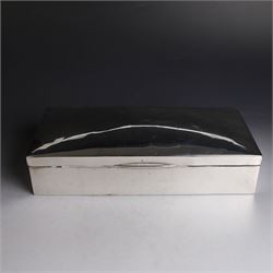 Two silver cigarette boxes, comprising early 20th century plain rectangular example with compartmentalised softwood interior, hallmarked Birmingham 1914, maker's mark indistinct, and an early 20th century example with engine turned decoration and engraved initials to cover, hallmarks worn and indistinct, largest H4.5cm, W21cm