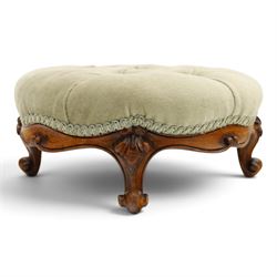 Victorian carved walnut framed armchair with matching stool, the tub-shaped chair with moulded and shaped frame and arm terminals, raised on scrolled cartouche carved supports with scroll feet and castors, buttoned back and sprung seat upholstered in sage green fabric; the small circular footstool with buttoned seat and scroll supports (W36cm H15cm)