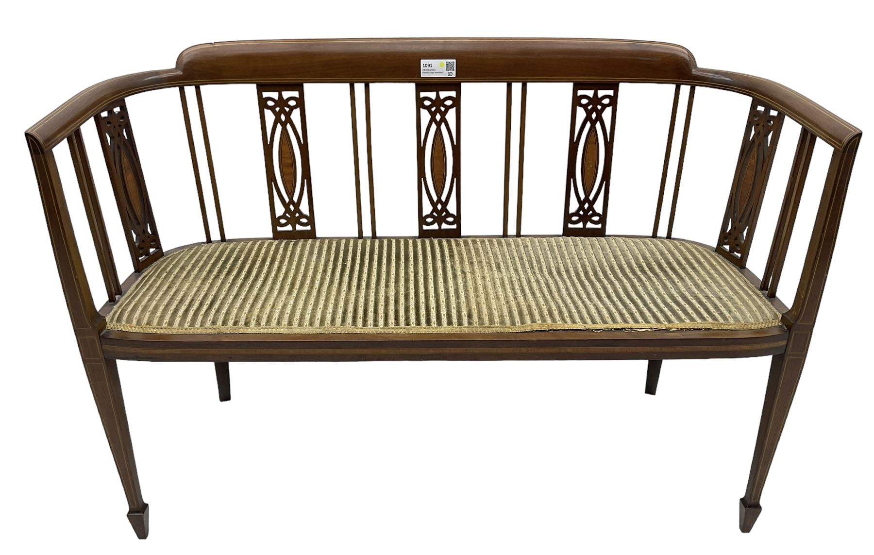 Edwardian inlaid mahogany two-seat salon sofa, curved back and arms inlaid with boxwood stringing, vertical slat back with pierced splats inlaid with satinwood, upholstered seat, on square tapering front supports with spade feet 