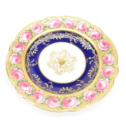 Early 19th century Coalport three handled goblet vase, shape no 114, and pair of plates, each hand painted with flowering pink roses upon a gilt band, against a dark blue ground heightened with trailing gilt tendrils, each marks beneath Coalport Swansea Period 1818, including handles vase H22.5cm, plates D23cm