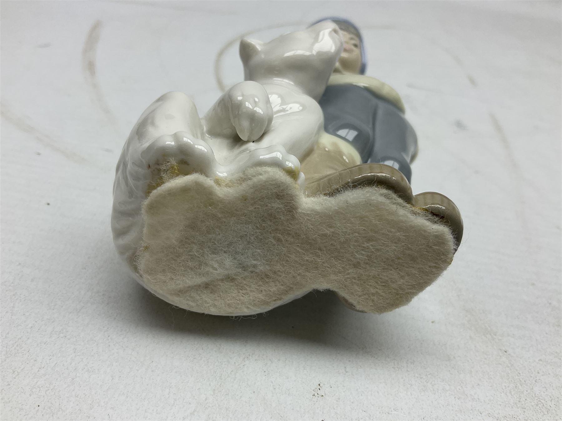 Seven Lladro figures, comprising Playful Puppy no 9135, Platero and Marcelino/Boy Hugging Donkey no 1181, Mini Seal Family no 5318, Attentive Polar Bear no 1207, Seated Polar Bear no1209, Eskimo Boy with Pet no 5238 and Girl with Geese no 1035, together with Nao goose