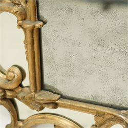 George III Chippendale design carved giltwood and gesso wall mirror, the impressive protruding pierced pediment decorated with flared acanthus leaves interspersed with flower heads and berries, over an arched outer-frame - the cresting comprised of C-scrolls carved with dripping icicle motifs, the uprights formed of scrolling acanthus with swags of grapevines and foliage, over a scrolled cartouche terminal, the inner-frame of architectural form with bell-flower details and a shaped cresting with scrolling acanthus leaves, all enclosing a central slightly bevelled rectangular mercury glass plate, surrounded by smaller plates