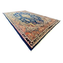 Persian Herati design indigo and red ground carpet, decorated with floral motifs, arched border
