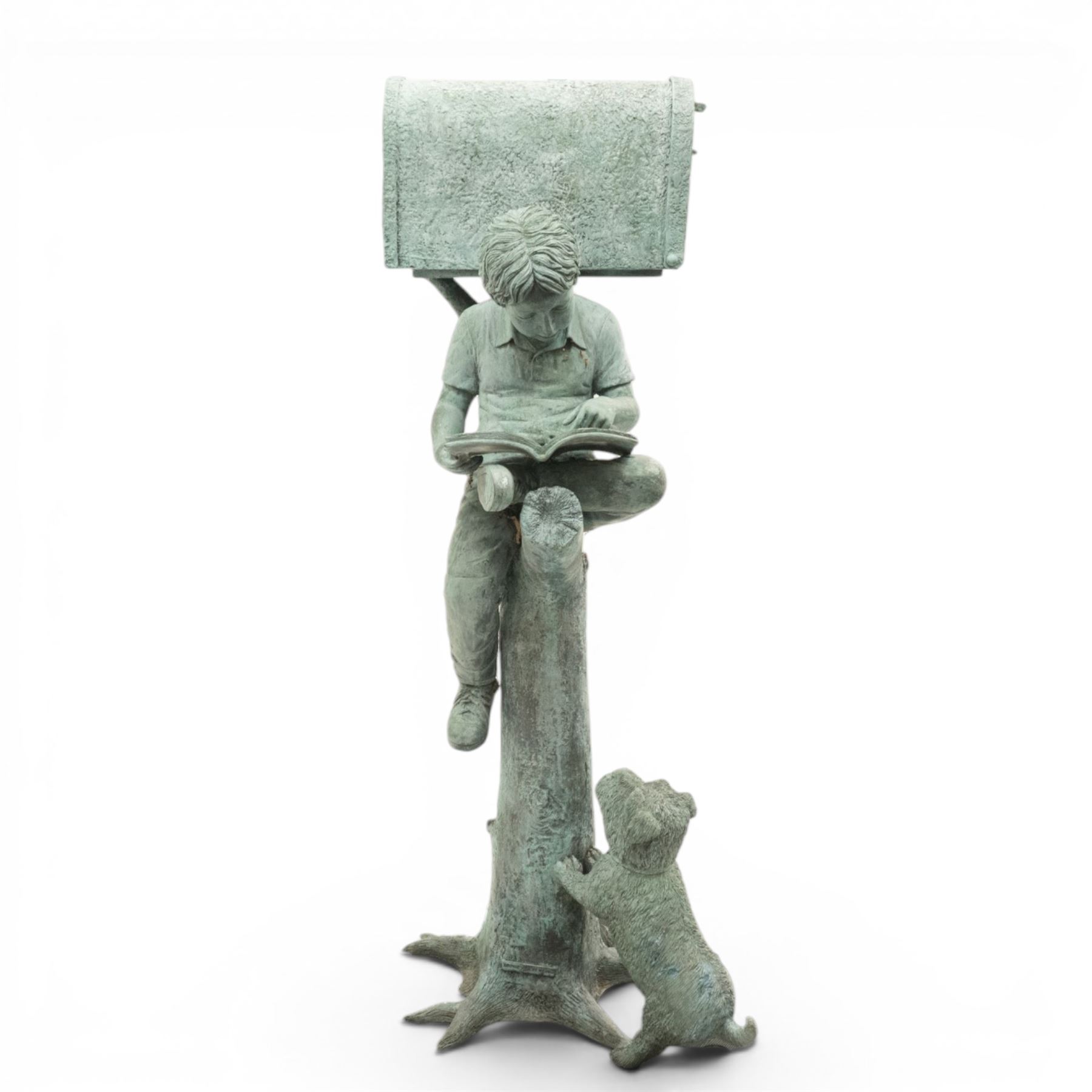 After Eneri Prosperi, bronze garden letterbox, modelled as a seated boy reading on a tree stump, with rustic post box with mail indicator, dog at his feet, textured verdigris finish throughout