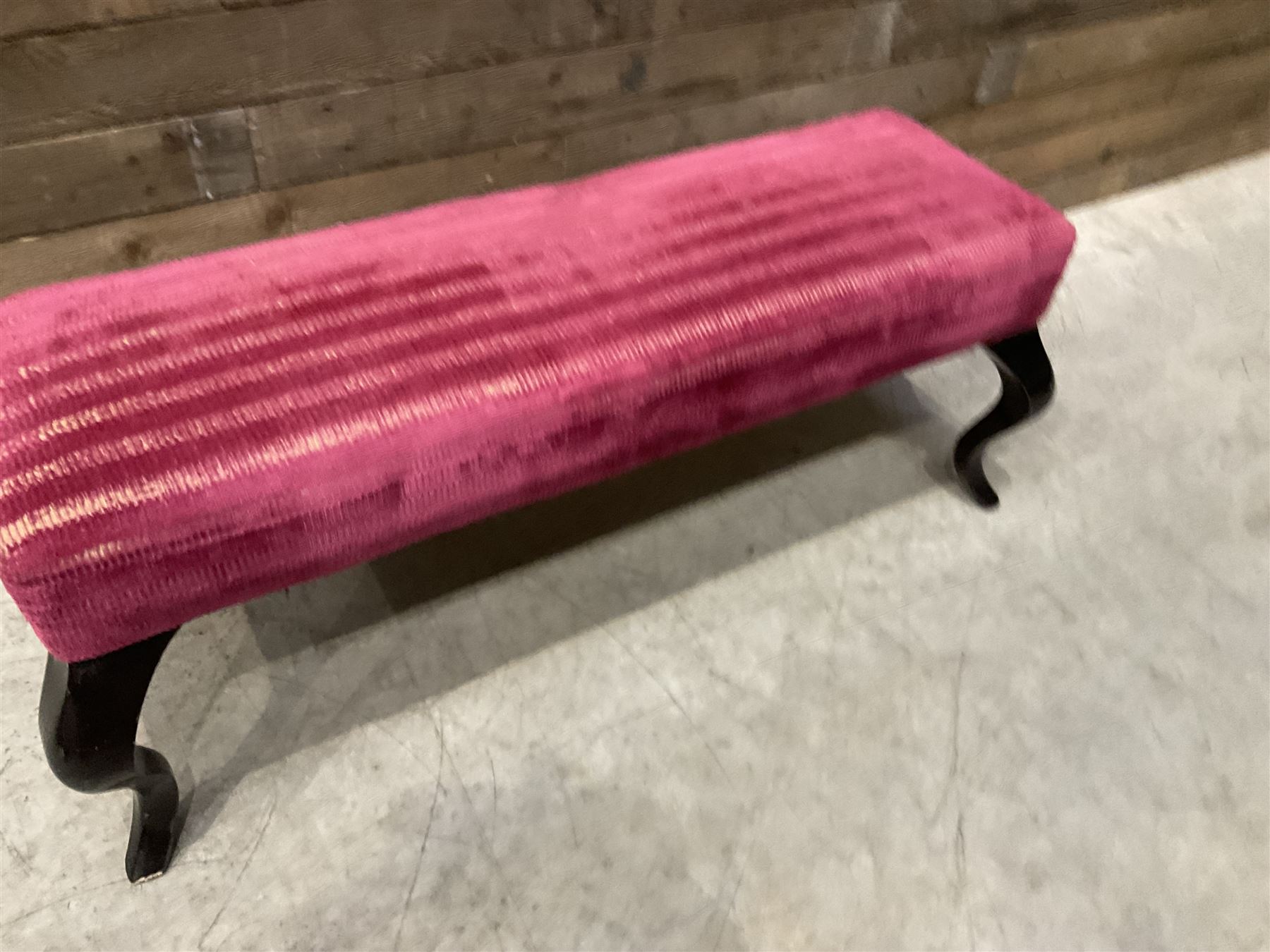 Large rectangular footstool upholstered in a maroon fabric with cabriole supports