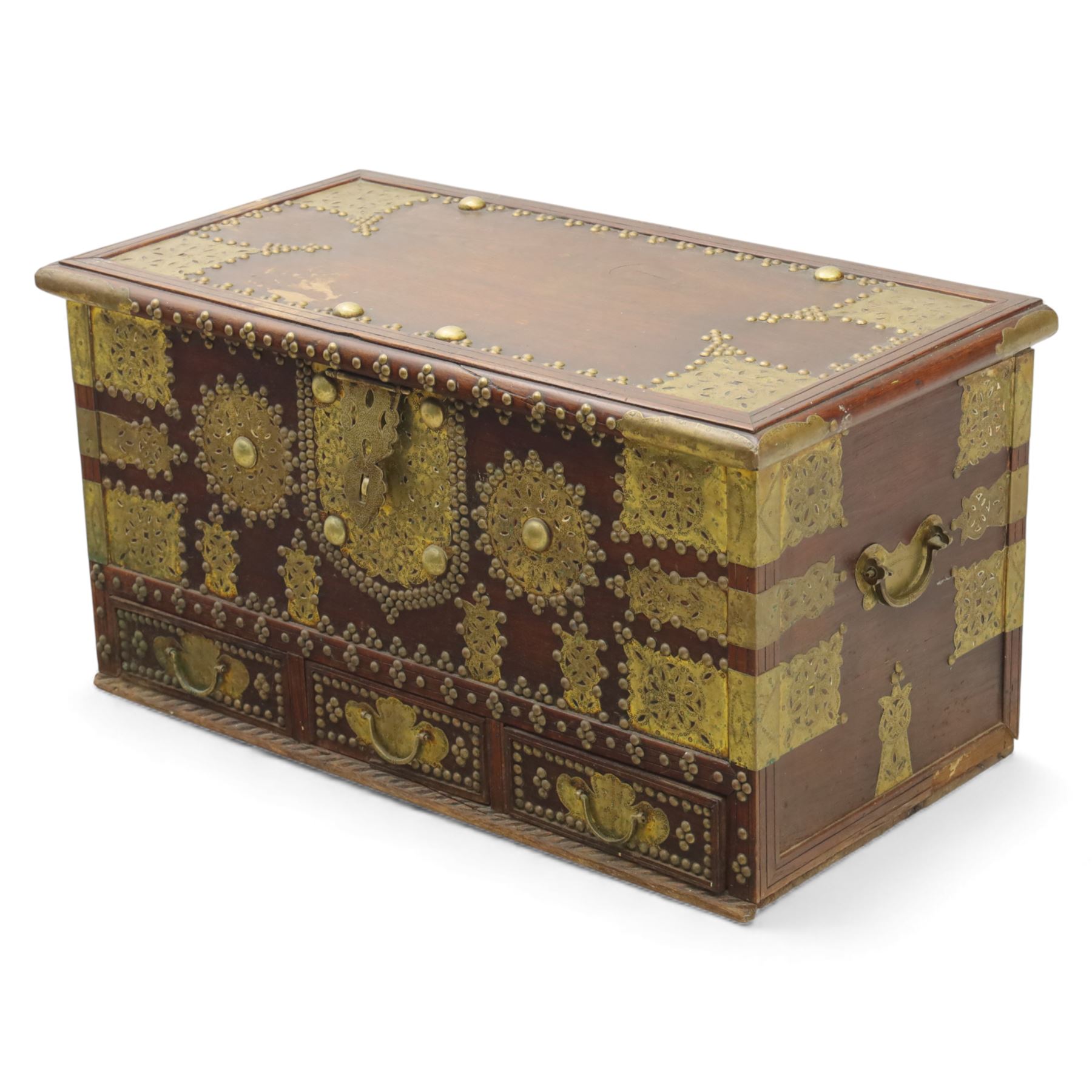 Early 20th century brass-mounted hardwood chest, the hinged top and front richly decorated with applied and studded brass panels and pierced lock escutcheon, revealing a candle box, reinforced with brass corner mounts