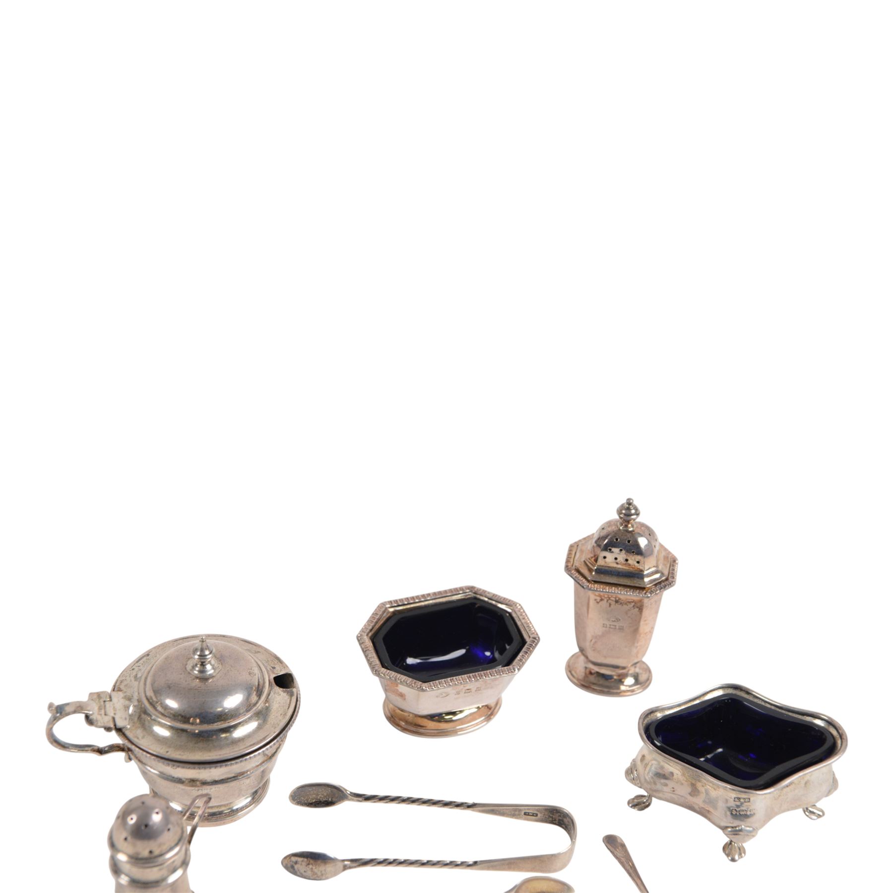 Collection of silver cruet items and flatware, including miniature muffineer, two pairs of sugar tongs, mustard pot and cover, open salts and pepper shaker, all hallmarked