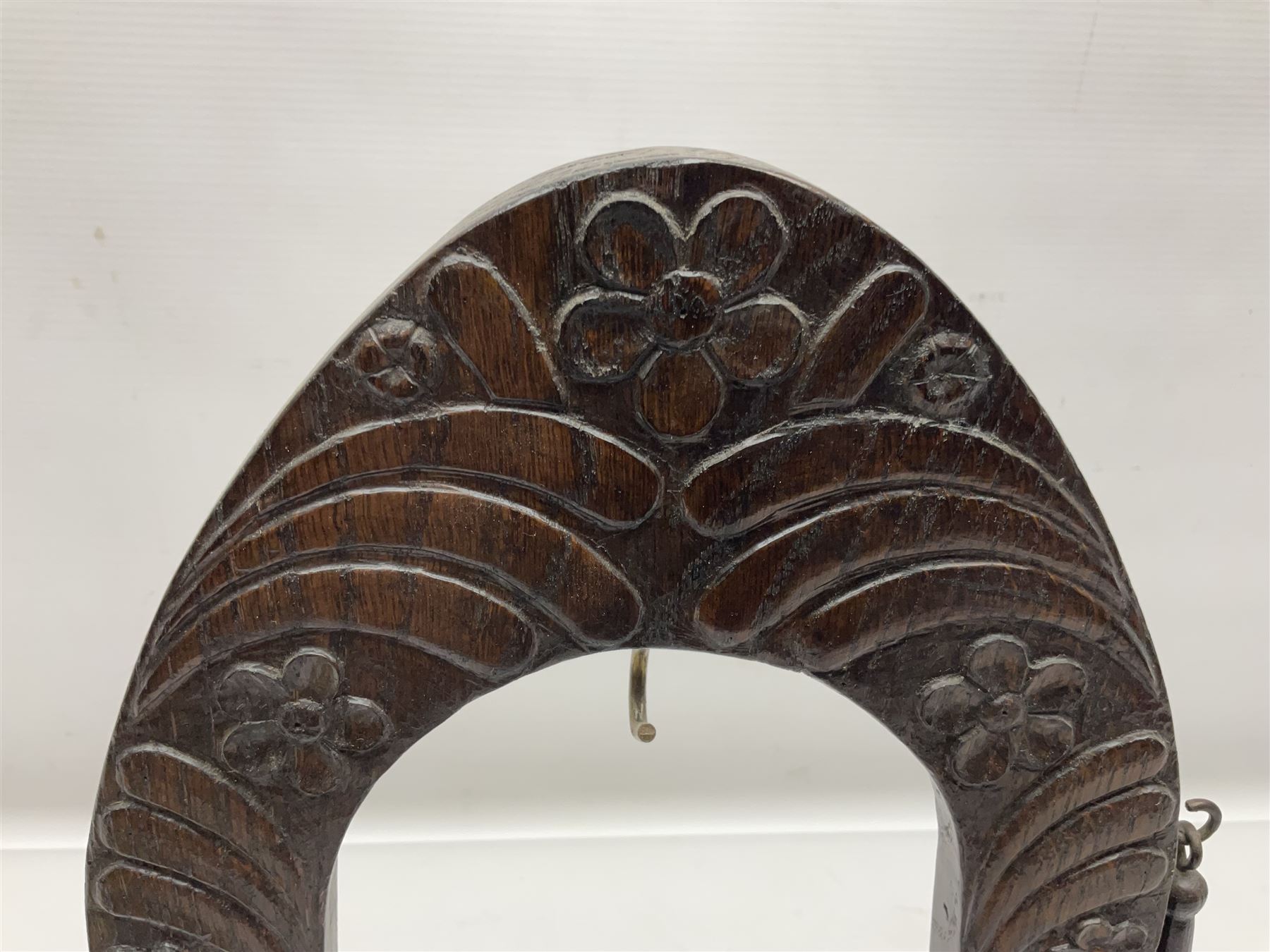 Chinese brass temple bell, decorated in high relief with a a dragon chasing a flaming pearl, within a carved floral hardwood stand, H36cm