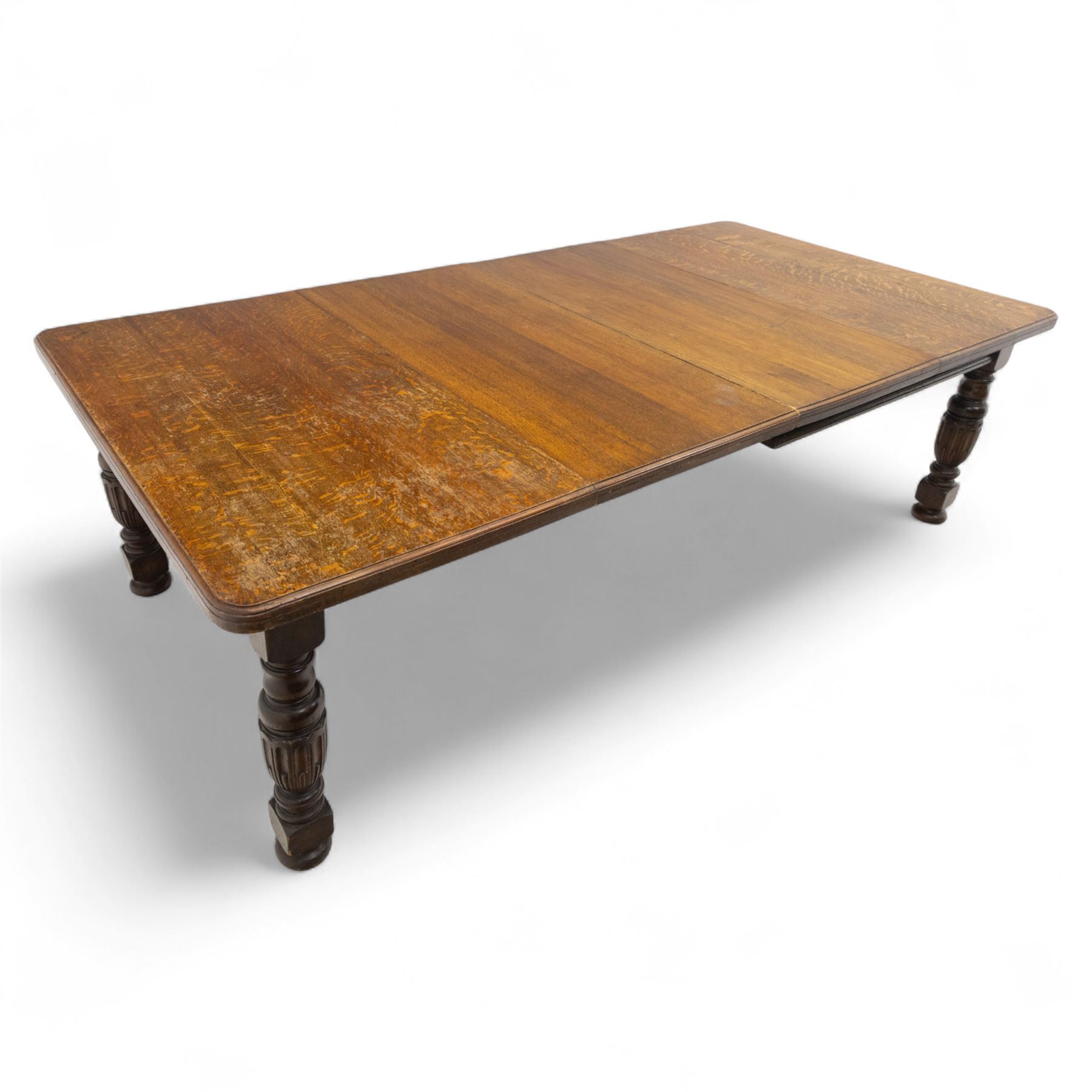 Victorian oak extending dining table, rectangular moulded top with figured grain pattern and wind-out action operated by removable crank handle, complete with additional leaves, raised on four boldly turned and reeded baluster supports terminating in squat bun feet (Extends to 238cm)