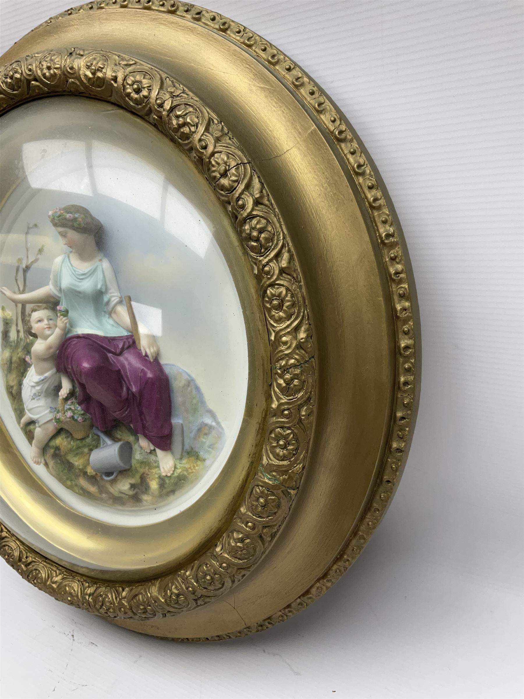 Set of four early 20th century Continental bisque plaques, each of circular form, modelled in high relief as the Four Seasons personified, within gilded circular frames under convex glass, overall D44.5cm