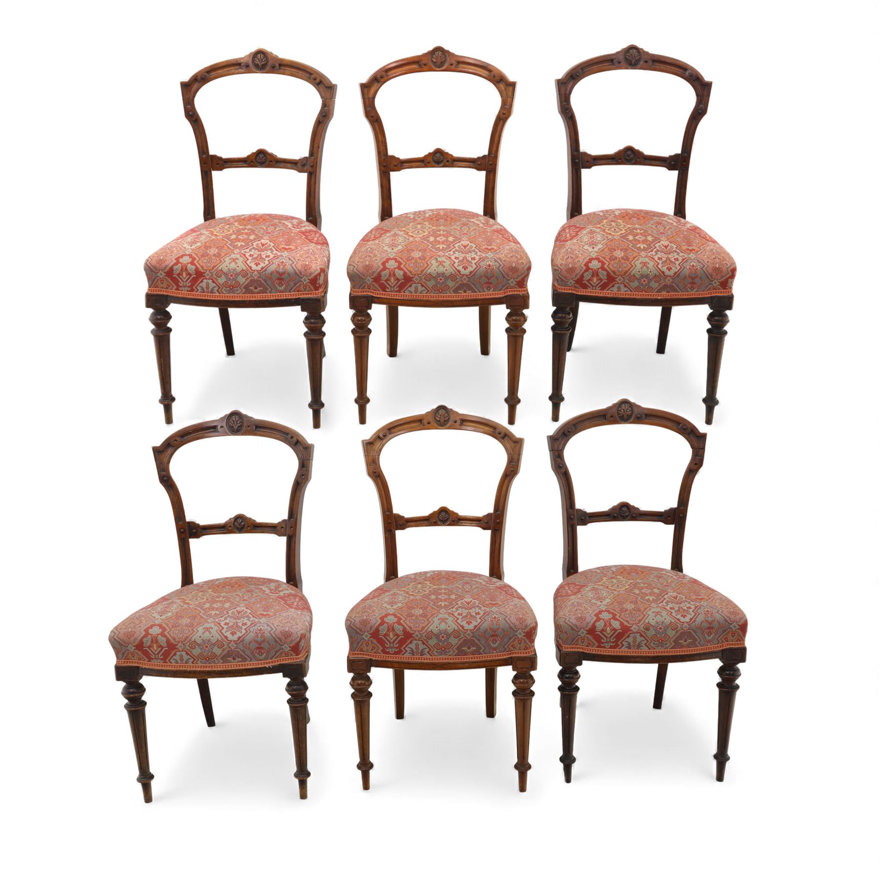 Set of six late Victorian mahogany dining chairs, the shaped top rails carved with anthemion motifs, above pierced splats, floral and geometric fabric seat, on turned and fluted front legs
