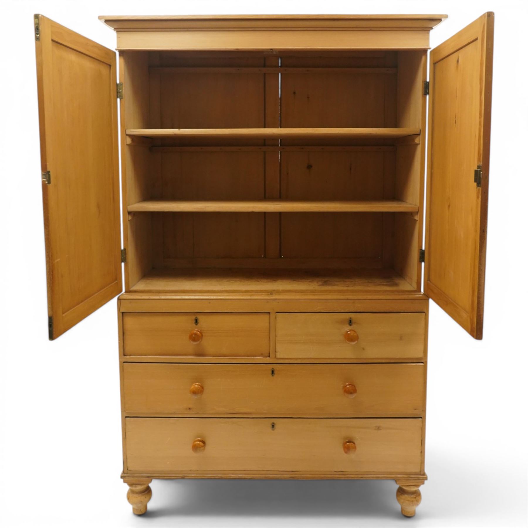 Victorian stripped pine housekeepers cupboard, projecting cornice over two panelled cupboard doors enclosing two shelves, the base fitted with two short over two long graduating drawers, lower moulded edge over turned feet