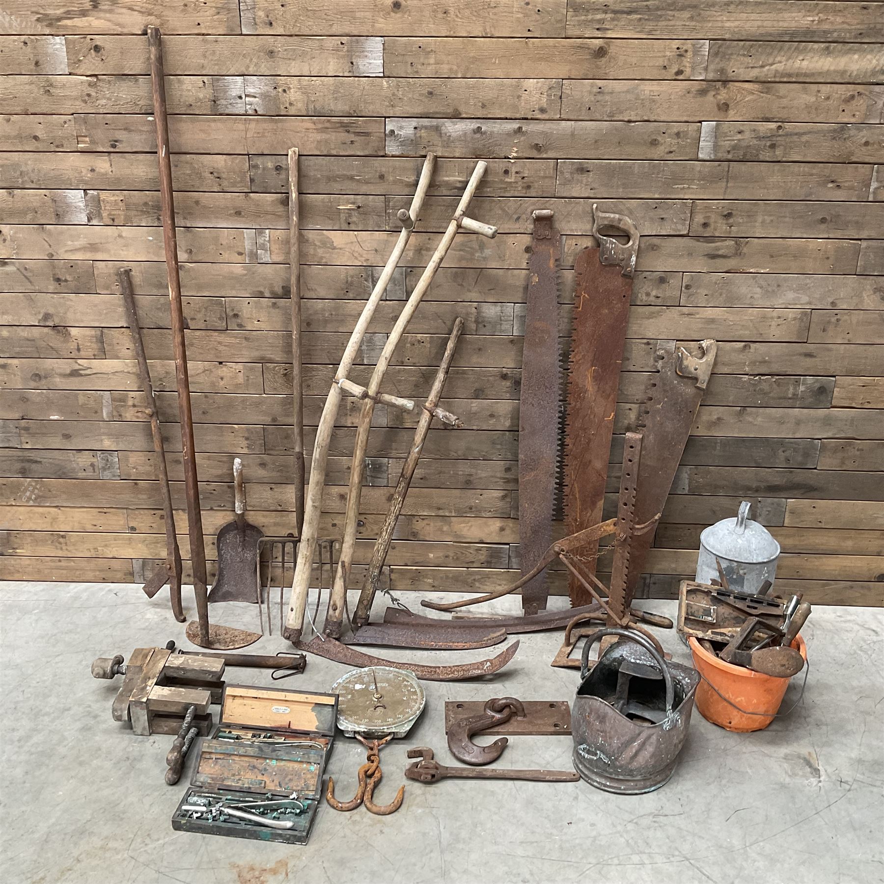 Large quantity of vintage hand tools including scales, scythes, saws etc