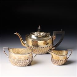 Late Victorian bachelors silver tea set of oval form with half body decoration, the teapot...