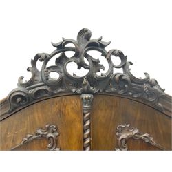 Early 20th century Italian walnut armoire wardrobe, the pierced and scrolling pediment carved with acanthus leaf detail, flanked by two scrolling cartouche with matching corbels below, the two panelled doors with applied carved rinceaux slips, with a central spiral turned upright, enclosing single shelf and hanging rail, raised on scroll feet