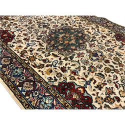Persian ivory ground rug, central green floral pole medallion within a field decorated by scrolling foliate patterns, the guarded border with repeating palmettes and floral designs