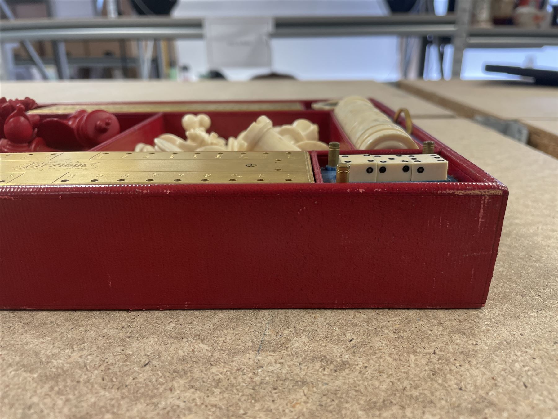19th century walnut and brass bound games compendium box, painted to enhance the grain, of rectangular form, the hinged opening cover with rounded sides, central brass cartouche with engraved lion crest, and brass riveted straps, opening to reveal a red leather and blue silk lined compartmented interior, with fold-down games board, and lift-out tray containing playing cards, ebony turned dice towers, white and red stained bone draughts, and chess pieces, ivory dice, and ivory and ebony whist markers, and brass bezique board, cribbage board and markers, H15cm W32cm D24cm
This lot has been registered for sale under Section 10 of the APHA Ivory Act