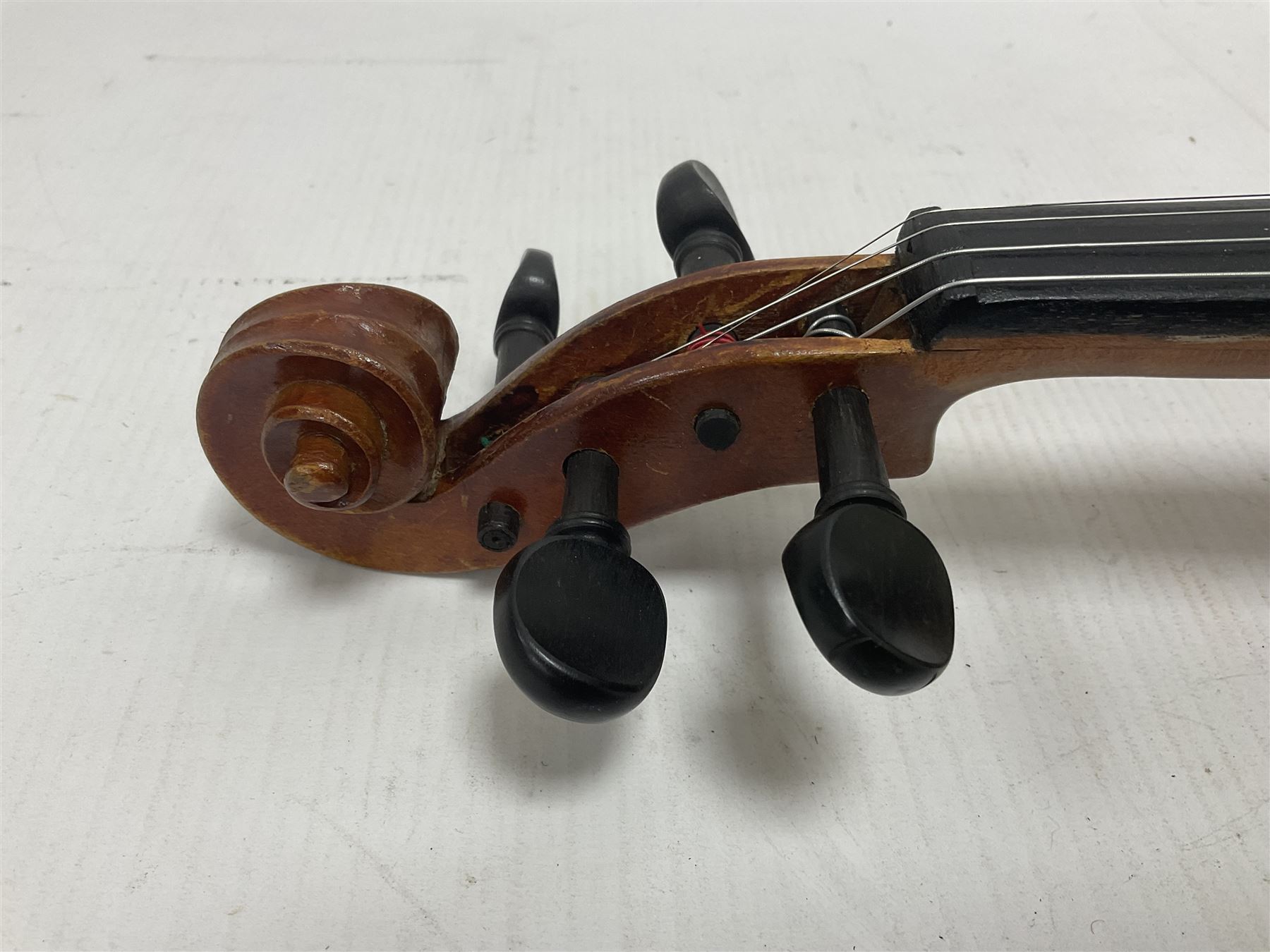 Copy of a full size Stradivarius violin, with an ebonised fingerboard, tailpiece and tuning pegs Length 60cm