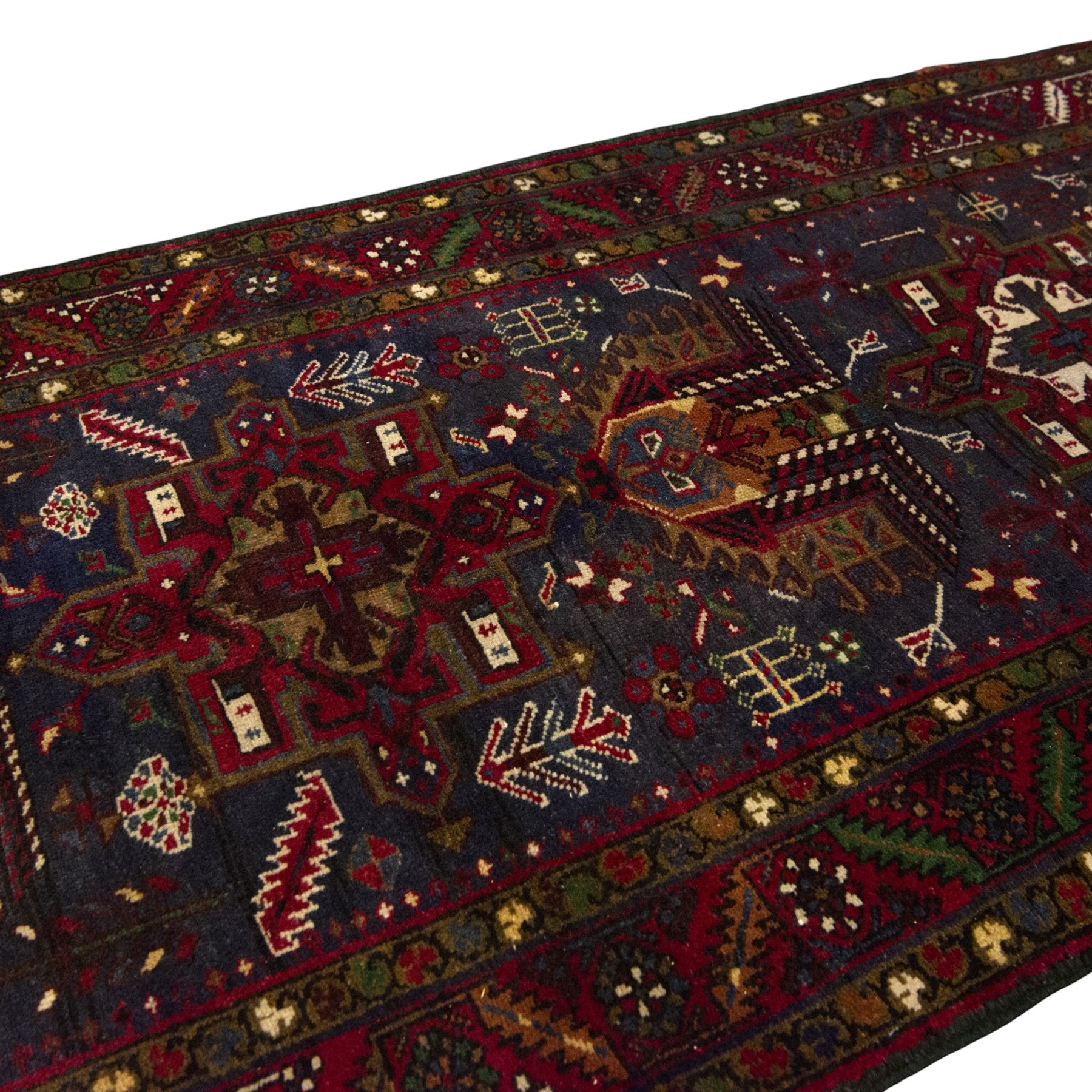 Large Northwestern Persian Hamadan hand-knotted runner, indigo field, with a column of bold geometric medallions and scattered stylized motifs within a madder border of angular rosettes and meandering vines 