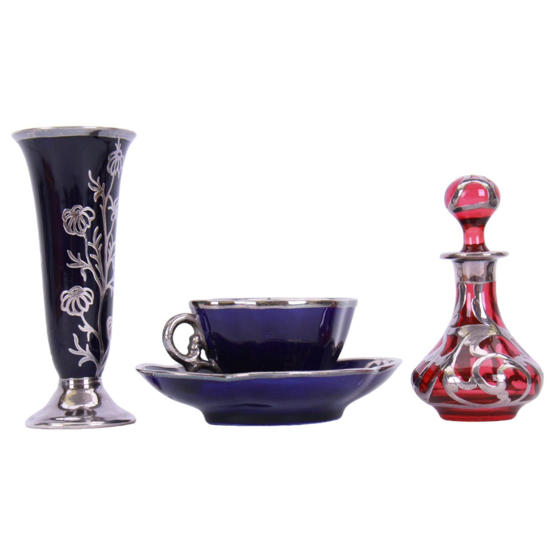 Cranberry glass scent bottle with silver overlay, together with German fluted vase with silver overlay upon a blue ground and similar teacup