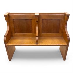 Pair of mid 20th century oak ecclesiastical pews, each with panelled backrests and shaped end supports, of solid construction and mellow honeyed tone