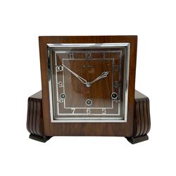  A  1930s “Bentima” Westminster chiming English art deco mantle clock in a stylised mahogany case with a square dial, chrome Arabic numerals and corresponding pierced hands within a chrome bezel, three train Perivale movement chiming the quarters on 4 gong rods, strike/silent facility. With pendulum and key. H24 



