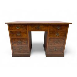 Late 19th to early 20th century walnut pedestal desk, rectangular top inset with red tooled leather writing surface, over a central frieze drawer flanked by two pedestals, each fitted with four graduated drawers with brass escutcheons and drop handles, the whole raised on a plinth base