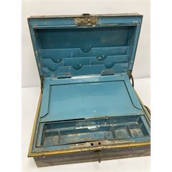 Black metal deed box, decorated with gilt banding and brass fixtures, with twin handles, the hinged lid with label remnants lifting to reveal blue compartmented interior with lift out tray containing lockable box, and a writing stand with two inkwells