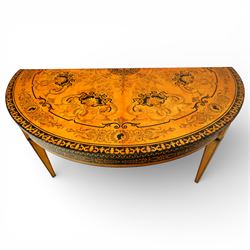 20th-Century Louis XVI-Style satinwood and penwork circular table or pair of console tables, the circular quarter-veneered top decorated in penwork with a central classical mask head motif within scrolling foliate and anthemion ornament on a contrasting black ground, above a conforming frieze decorated with Greek key-type scrolls. Raised on square tapering legs, each with an upper block panel decorated with compass-star motifs.