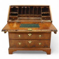 18th century walnut and herringbone banded bureau, the fall front enclosing a stepped and arched interior fitted with pigeonholes, drawers and concealed compartments, green tooled leather writing surface, over two short and three long graduated drawers with brass escutcheons and bail handles, shaped bracket feet