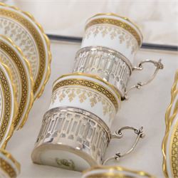 Boxed set of six Aynsley coffee cans and saucers, decorated with gilt greek key border, the cans within silver mounts, hallmarked Birmingham 1911