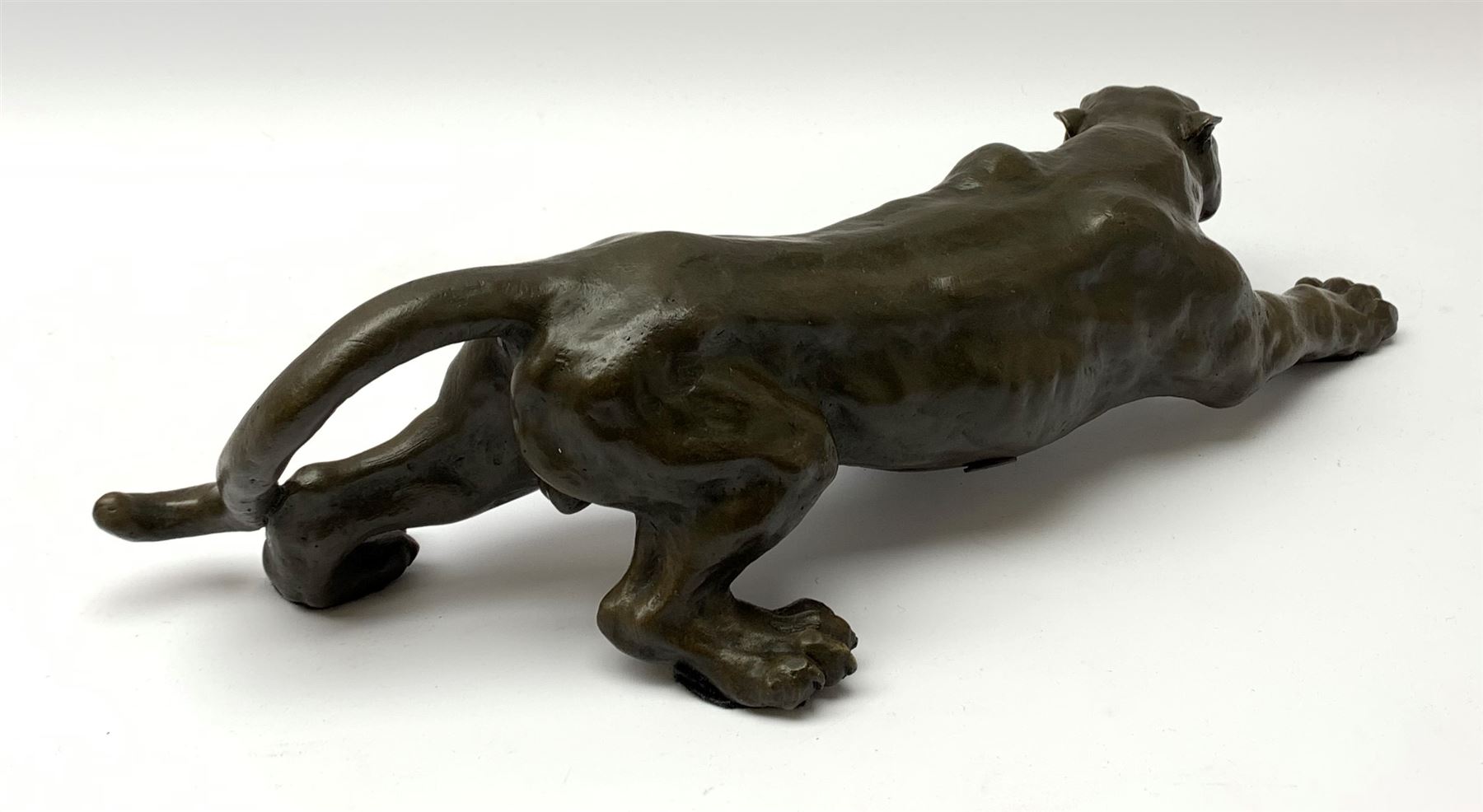A bronze figure, modelled as a cougar in crouching pose, signed Milo and with foundry mark, L40cm.
