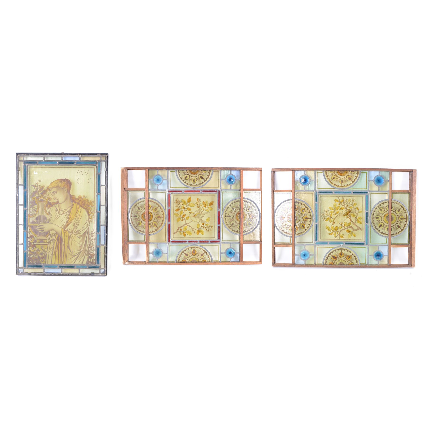 Two stained glass leaded panels each decorated with birds in foliate to to the centre, together with another panel with a female figure to the central panel, largest L78cm, H53cm