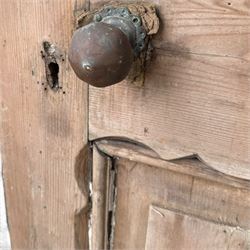Victorian stripped pine four-panel door, the raised fielded panels within carved foliate and moulded surrounds, with iron lock and fittings and brass knob handle