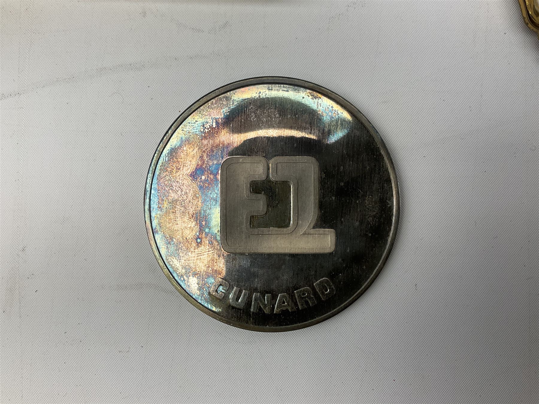 Silver 1969 Cunard RMS Queen Elizabeth maiden voyage commemorative medallion, in original Slade, Hampton & Son case with certificate, two Stratton R.M.S Queen Elizabeth mirror compacts, Stratton R.M.S Queen Mary compact, mid 20th century P&O Canberra Round World Voyage miniature globe, S.S Oriana ash tray modelled as a barrel, Norah Wellings sailor doll, and other maritime and shipping memorabilia 