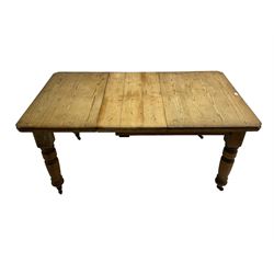 Late Victorian pine extending dining table, rectangular moulded top with canted corners and additional leaf, on turned supports with brass castors 