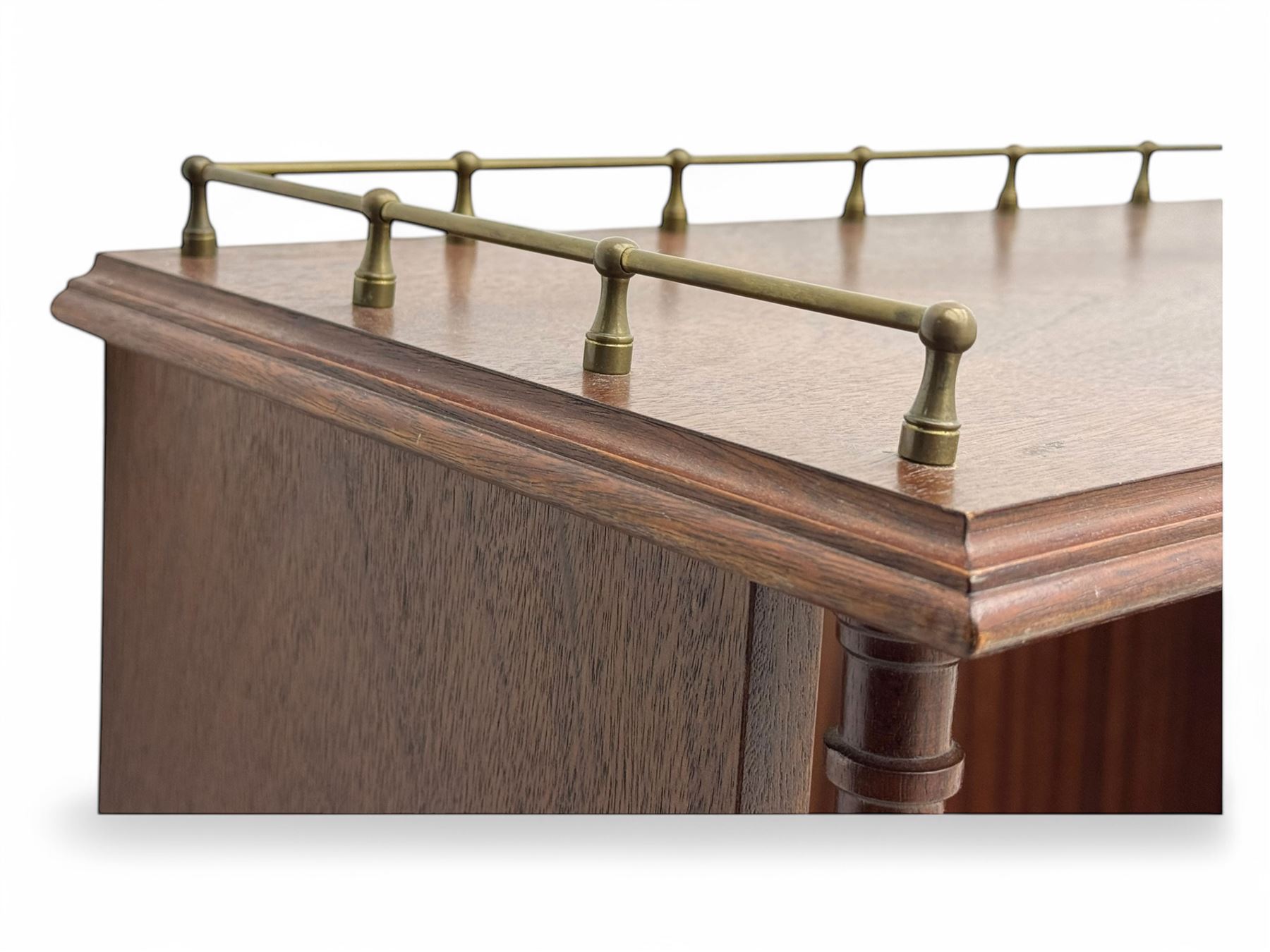 Mid-20th century mahogany open bookshelf, the rectangular top with a brass balustrade gallery, over three shelves each supported by turned column uprights, on shaped apron base