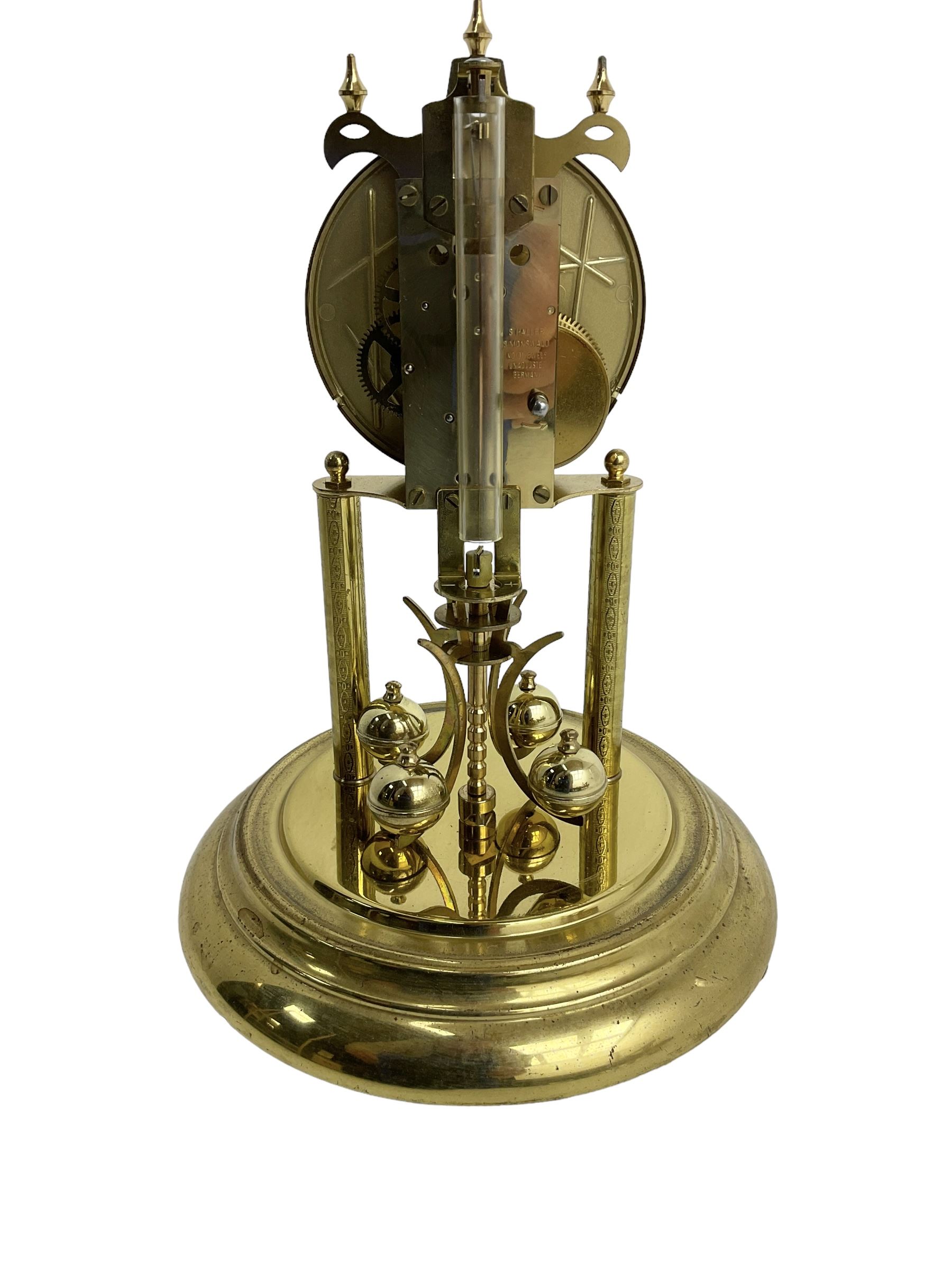 Late-20th century Haller torsion clock - German 400-day clock under an acrylic dome, with a gilt dial Roman numerals and pierced steel hands, on a circular brass plated base with pendulum lock, torsion suspension intact. with key. 
