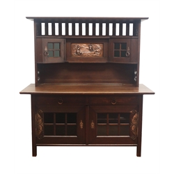  Art Nouveau stained oak sideboard, the pierced back and sides, with embossed copper plaque of a figure in a boat flanked by corner display cabinets, the base with two frieze drawers and two glazed cupboard doors with chased scrolling hinges, W152cm, H165cm, D72cm  