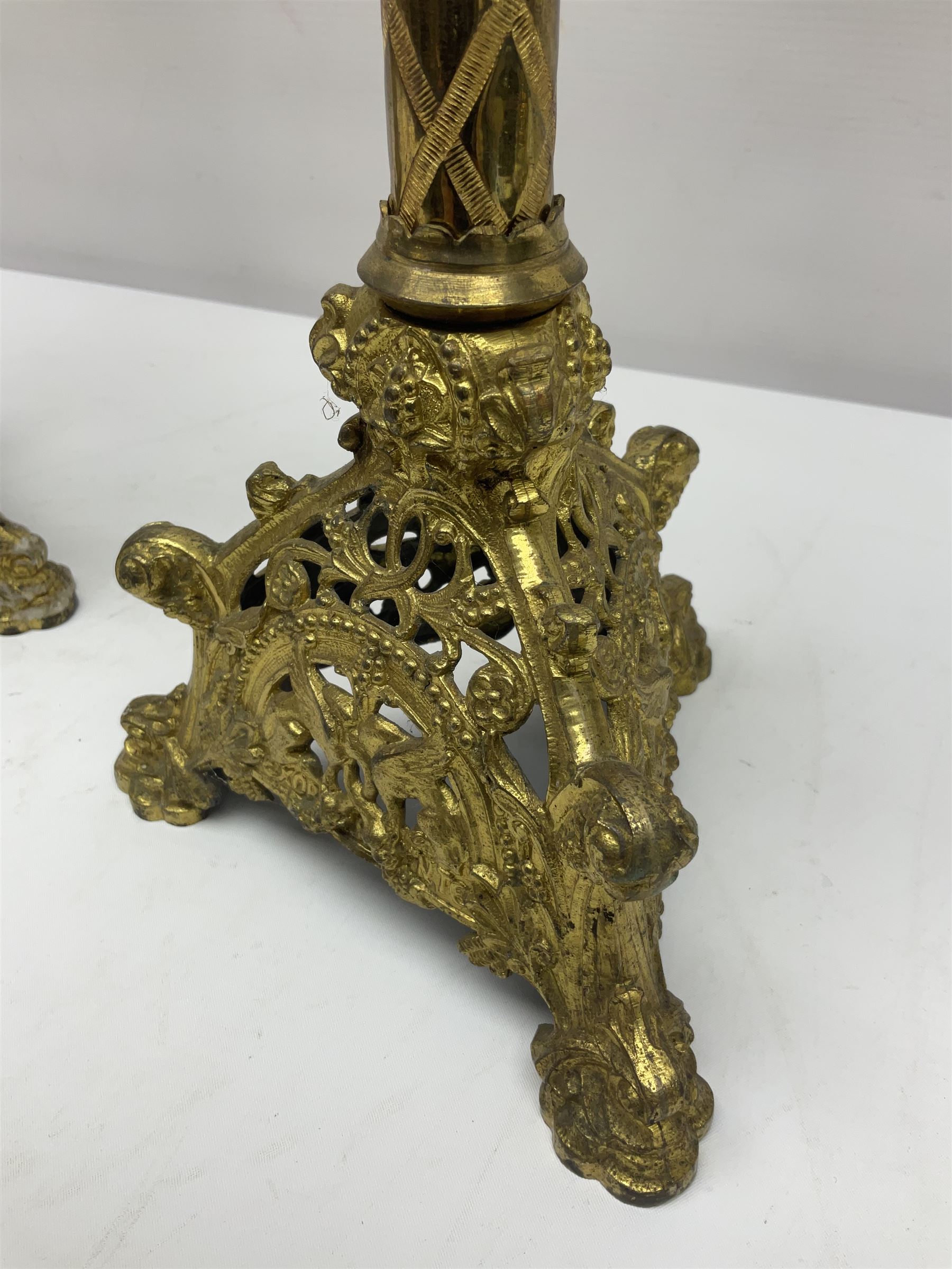 Pair of gilt metal pricket candlesticks, with applied decoration on knopt stems and triform bases, H47cm