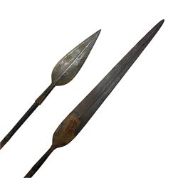 Native long-shafted spear, the large iron head with central medial ridge and decorative neck, on plain circular haft L260cm; and another similar Native long-shafted spear with cane haft L249cm (2)