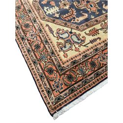 Persian ivory and peach ground, overall geometric design, the field with central star medallion surround stylised leaf motifs, guarded geometric design border