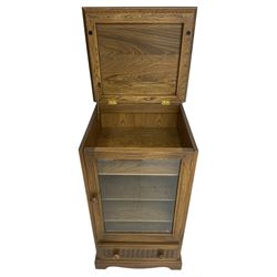 Ercol - mid-20th century dark elm 'Old Colonial' music cabinet, single glazed door enclosing three shelves, single drawer fitted to base
